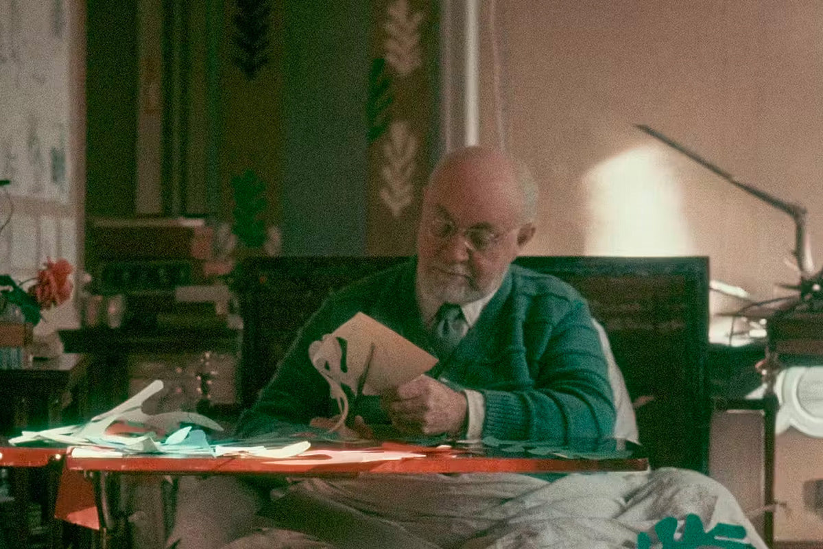 Henri Matisse in seinen letzten Lebensjahren, an seinem Tisch Formen aus bemaltem Papier schneidend
