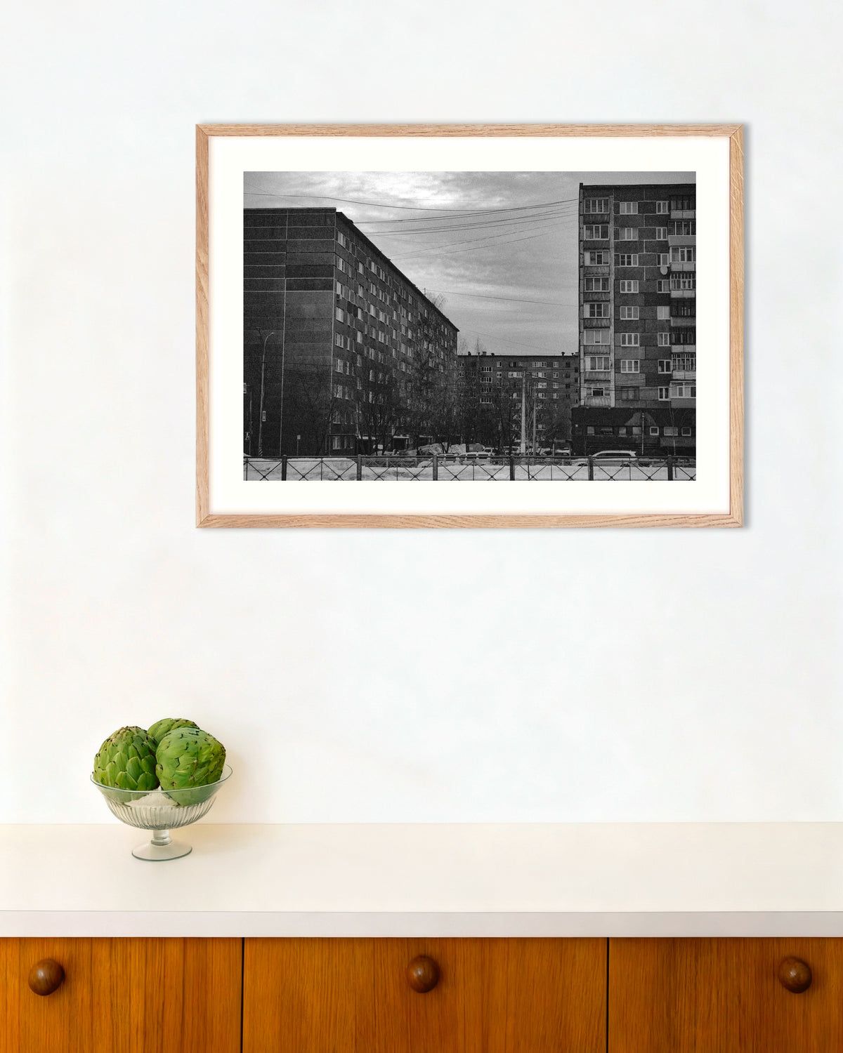 Poster „Plattenbauten im Winter“ mit naturfarbenem Holzrahmen